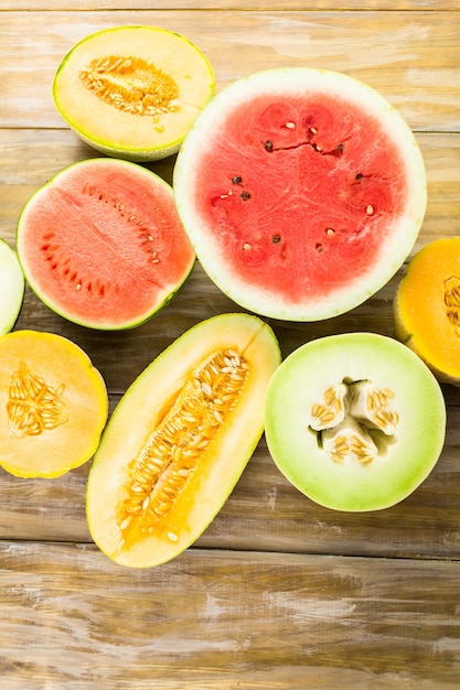 Varietà di meloni organici affettati sulla tavola di legno.