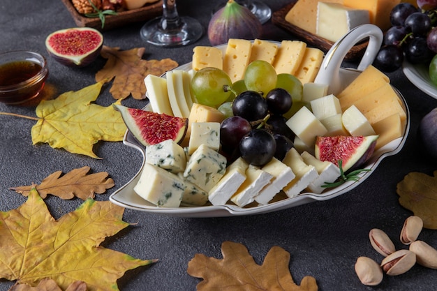 Varietà di noci e frutta al formaggio sul tavolo grigio Antipasto per il Giorno del Ringraziamento