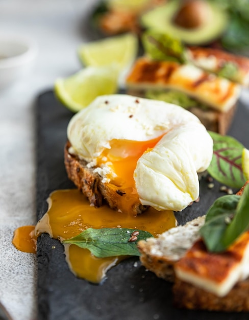 Varietà di panini con tartine, uovo in camicia, avocado e formaggio grigliato Concetto di cibo dietetico