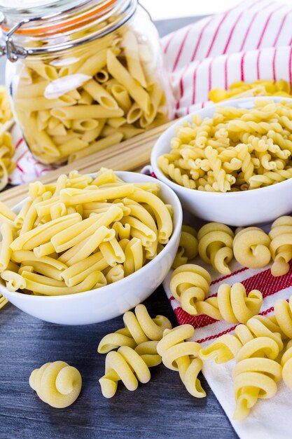 Varietà di pasta secca biologica su tavola di legno.