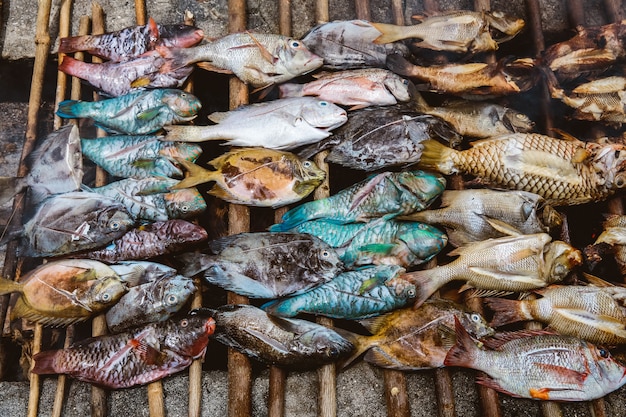 Varietà di pesce crudo grigliato su una griglia tradizionale