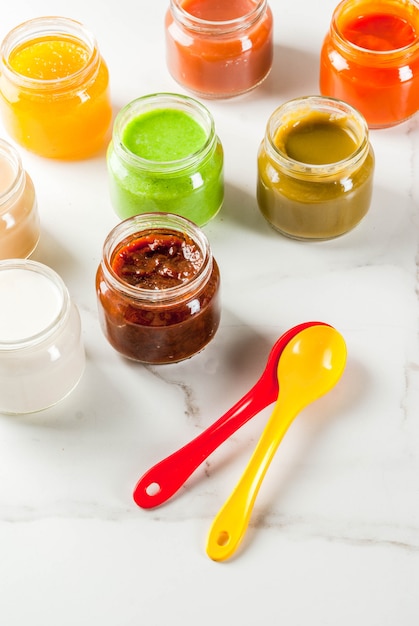 Varietà di purea di frutta e verdura casalinga per bambini, copyspace in marmo bianco