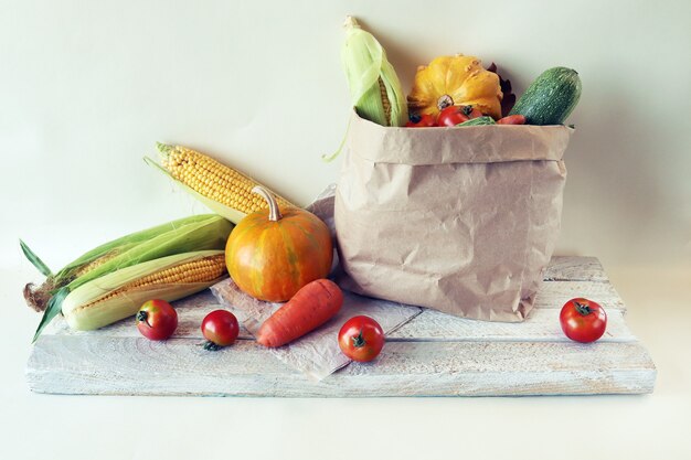 Varietà di verdure fresche e mature in un sacchetto di carta ecologico su sfondo chiaro