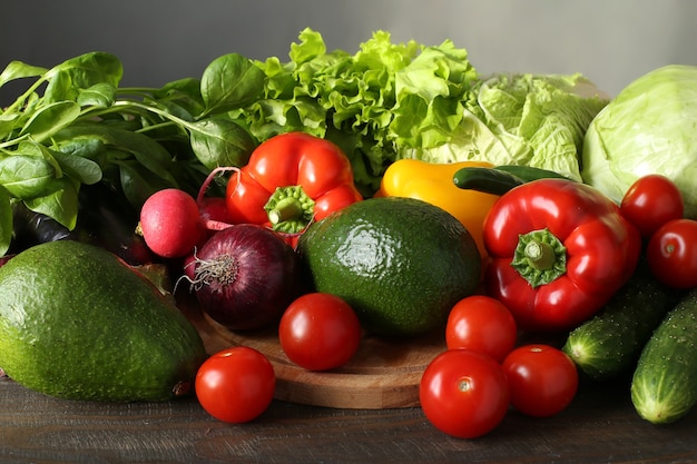 Varietà di verdure fresche pepe, ravanello, avocado, broccoli, melanzane, cavoli, pomodori, cipolla rossa su una tavola