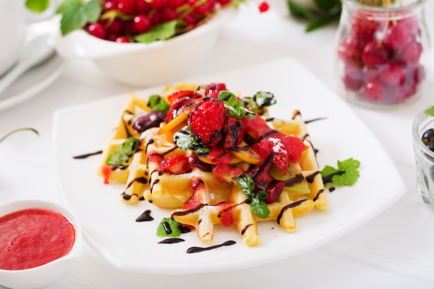 Varietà di wafer belgi con frutti di bosco, cioccolato e sciroppo