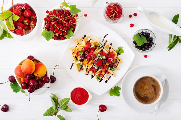 Varietà di wafer belgi con frutti di bosco, cioccolato e sciroppo