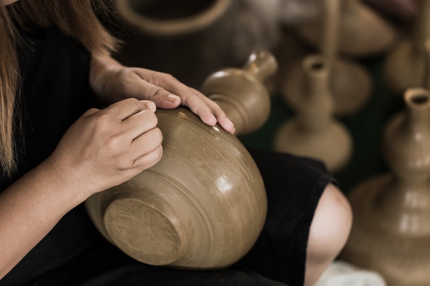 Vasaio asiatico senior che fa a mano terraglie del vaso di argilla.