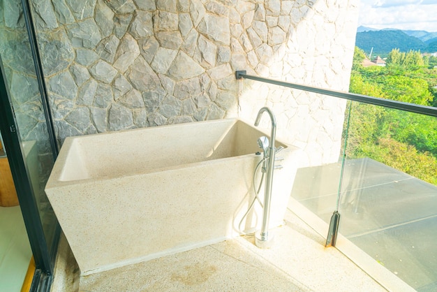 Vasca da bagno sul balcone con sfondo di collina di montagna