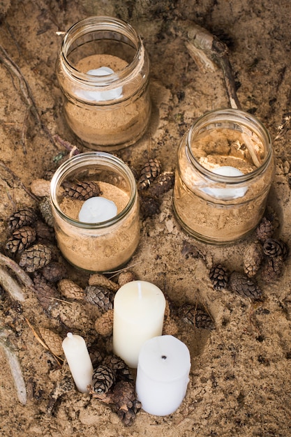 Vasetti con candele e decorazioni di sabbia in natura