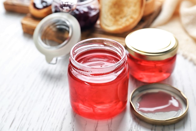 Vasetti con marmellata dolce sul tavolo di legno