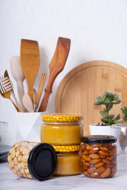 Vasetti di vetro con miele e noci Mandorle e nocciole nel miele all'interno della cucina