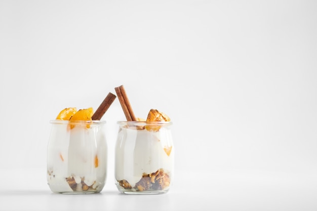 Vasetti di yogurt greco con muesli, cannella e albicocche in scatola