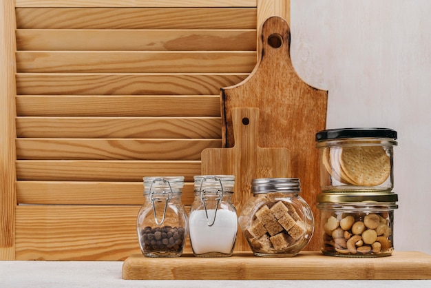Vasetti pieni di ingredienti alimentari e fondo in legno