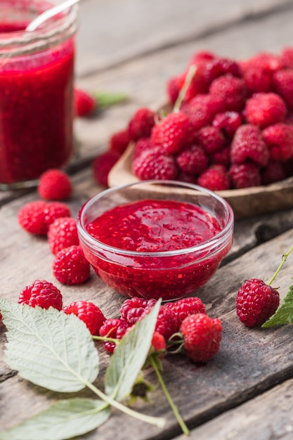 Vasetto di marmellata di lamponi e frutti di bosco freschi con foglie. Dolce dolce