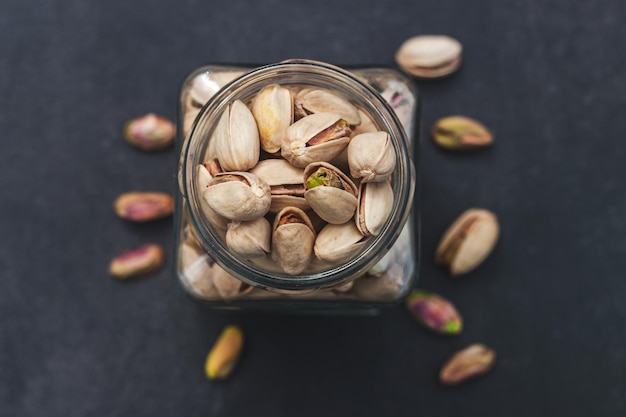 Vasetto pieno di pistacchio con fondo nero