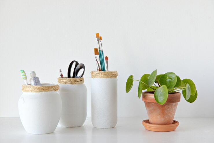 Vasi bianchi artigianali realizzati con pianta pilea su sfondo bianco in stile minimal
