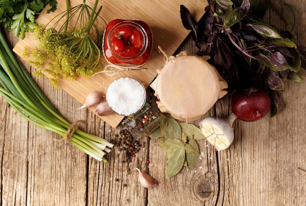 Vasi con pomodori in scatola su sfondo di legno