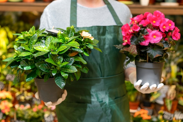 Vasi da fiori della tenuta dell'uomo di vista frontale con i fiori