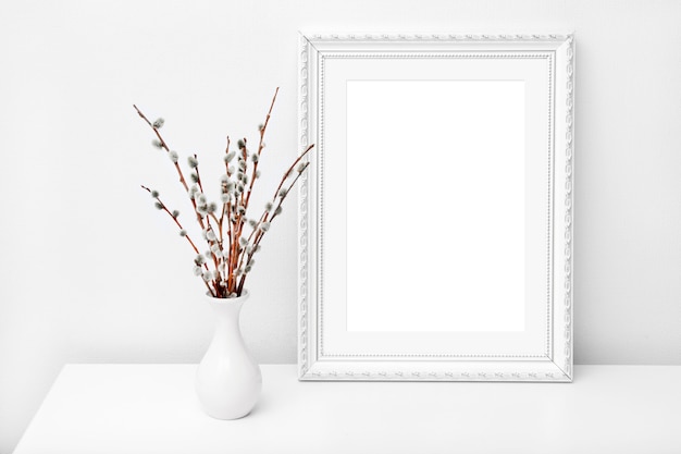 Vaso bianco e cornice con spazio di copia su un tavolo bianco