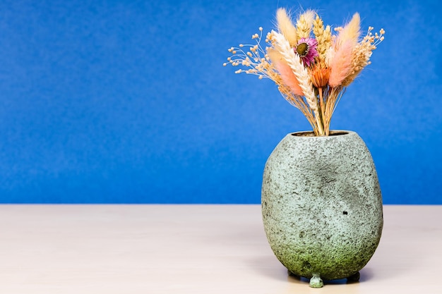 Vaso con bouquet di fiori secchi sul tavolo