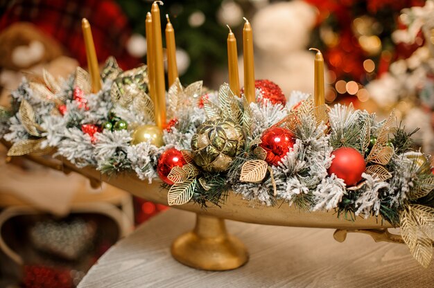 Vaso con composizione di decorazioni natalizie di fiori e candele