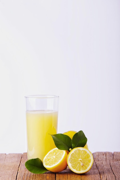 Vaso con limone e succo di limone su uno sfondo bianco