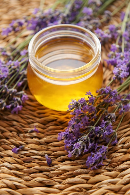 Vaso con miele e fiori di lavanda freschi