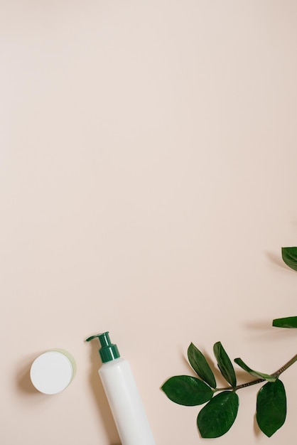 Vaso cosmetico bianco e una bottiglia di crema con una vista dall'alto delle foglie delle piante un mockup del design del prodotto Cosmetici biologici naturali