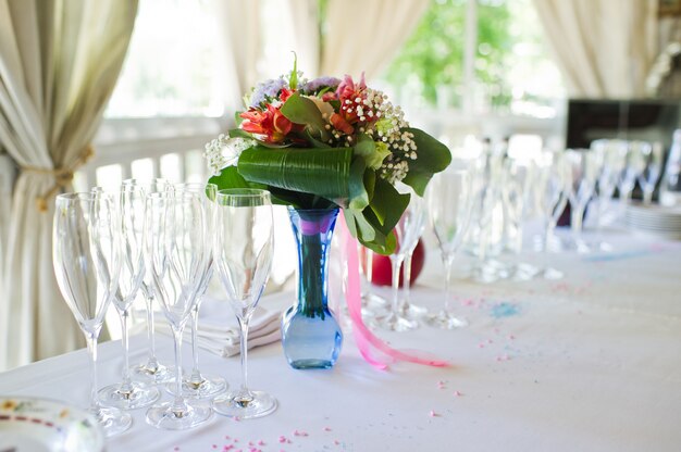 Vaso decorato con fiori freschi al banchetto nuziale.