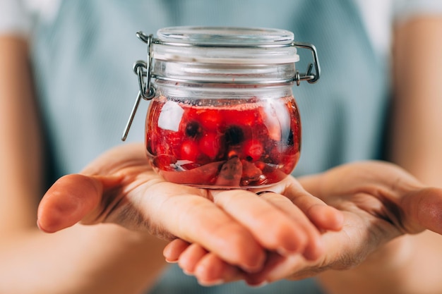 Vaso della holding della donna con frutta fermentata