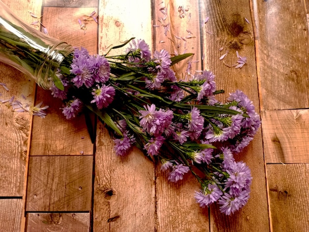 Vaso di fiori viola su fondo in legno