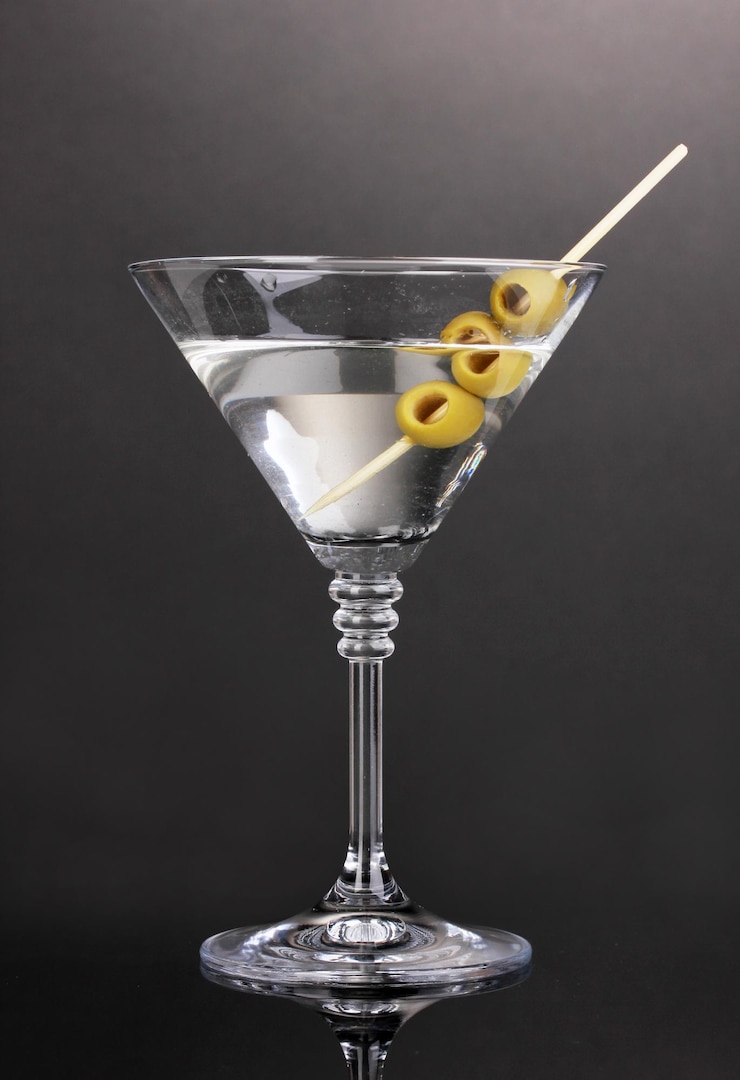 Foto vaso di martini e olive su sfondo grigio