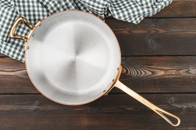 Vaso di rame con la tovaglia chekered sulla tavola di legno