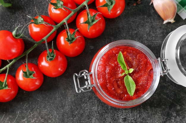 Vaso di vetro con gustosa salsa di pomodoro per la pasta sul tavolo