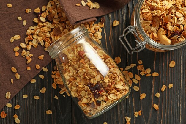 Vaso di vetro con gustoso muesli su sfondo di legno