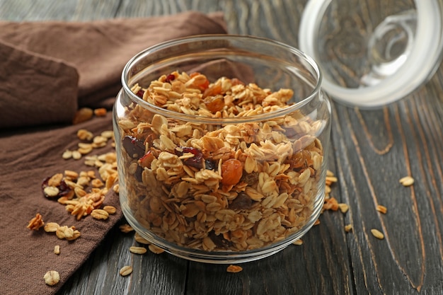 Vaso di vetro con gustoso muesli su sfondo di legno
