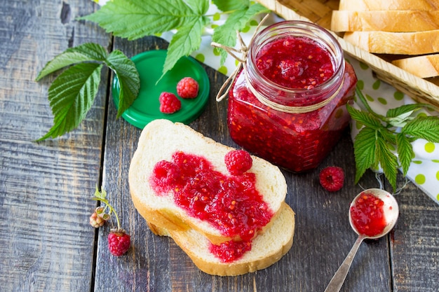 Vaso di vetro con marmellata di lamponi e foglie di menta