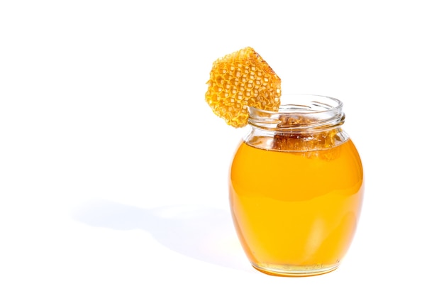 Vaso di vetro con miele dolce isolato su priorità bassa bianca.