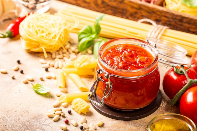 Vaso di vetro con pasta di pomodoro piccante classica fatta in casa o salsa di pizza.