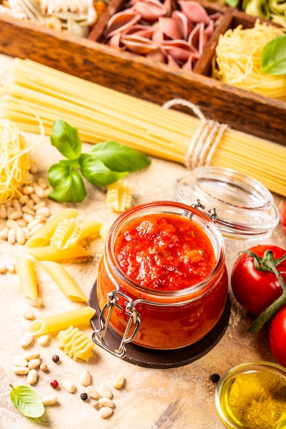 Vaso di vetro con pasta di pomodoro piccante classica fatta in casa o salsa di pizza.