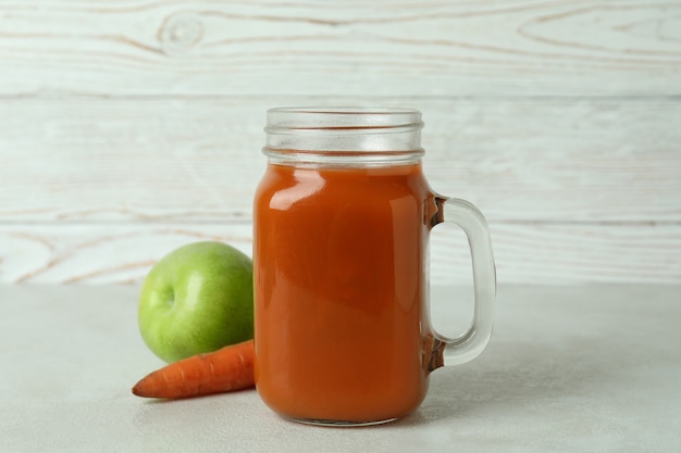 Vaso di vetro di succo e ingredienti su sfondo bianco isolato in legno