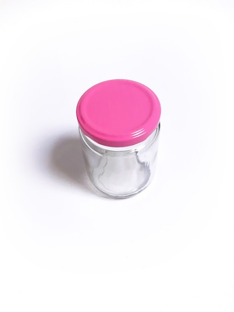 Vaso di vetro vuoto con tappo rosa isolato su sfondo bianco