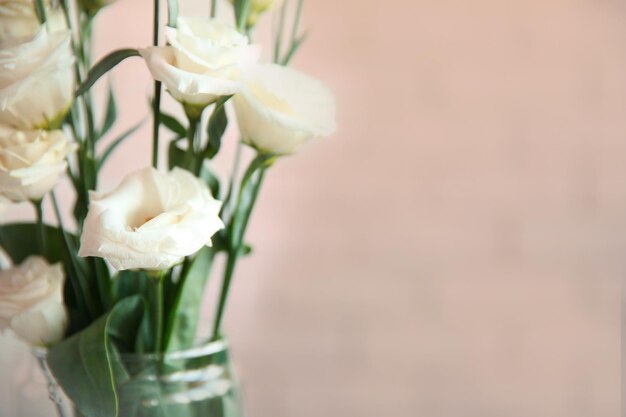 Vaso in vetro con bouquet di bellissimi fiori su sfondo colorato