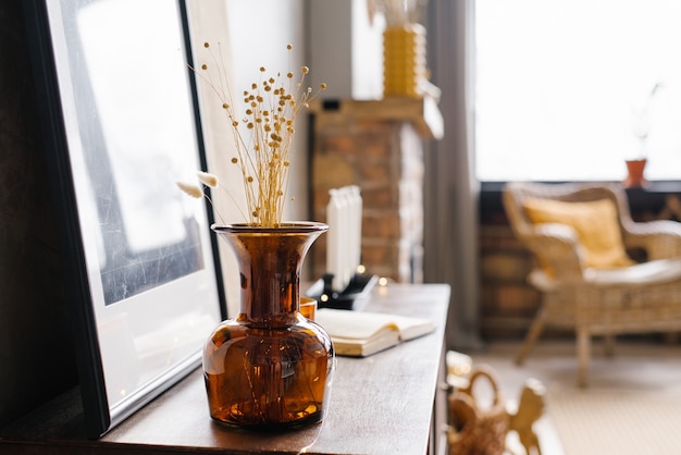 Vaso in vetro marrone con fiori secchi all'interno di una casa moderna. Copia spazio