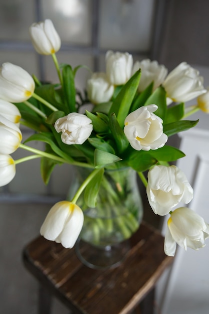 Vaso in vetro trasparente con bouquet di fiori di tulipani