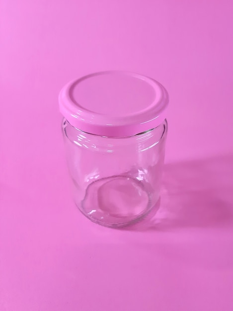 Vaso vuoto con tappo rosa isolato su sfondo rosa