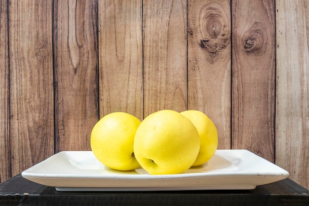 Vassoio bianco con mele dorate mature pronte da mangiare