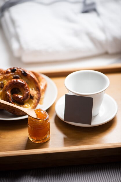 Vassoio con colazione su letto in camera d'albergo