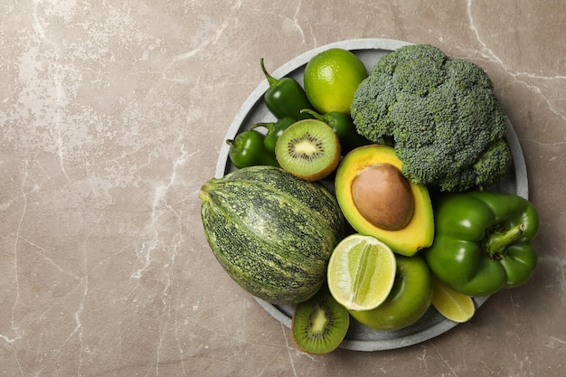 Vassoio con frutta e verdura verde sul tavolo grigio