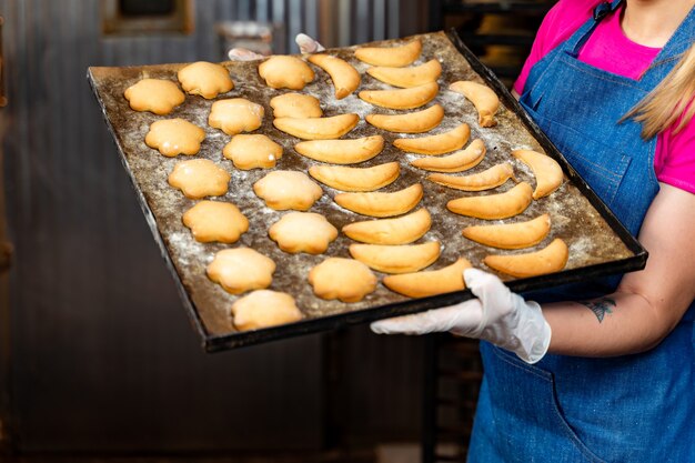 Vassoio di panini o focacce fresche. Panetteria calda dal forno. Panetteria o fabbrica di pane. La produzione da forno.